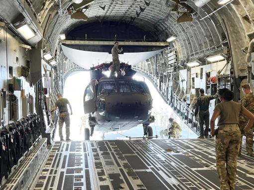 Soldiers assigned to Alpha Company, 3rd Battalion, 142nd Aviation, load a UH-60M Black Hawk helicopter on board an Air Force C-17 transport at Albany International Airport in Latham, New York on Sunday, April 28, 2024. The Battalion deployed four UH-60s--